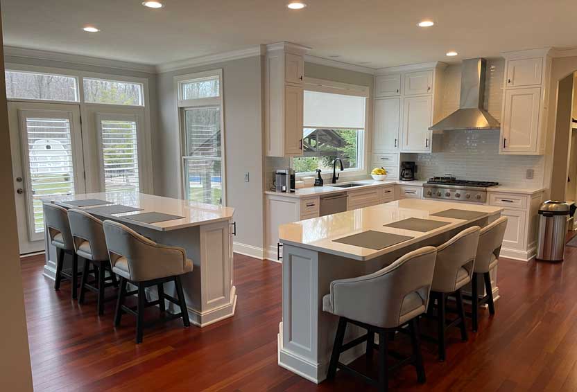 White double-island kitchen remodel by Tamer Construction