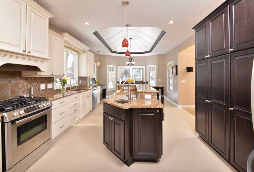 Two-tone kitchen remodel with tray ceiling and granite island